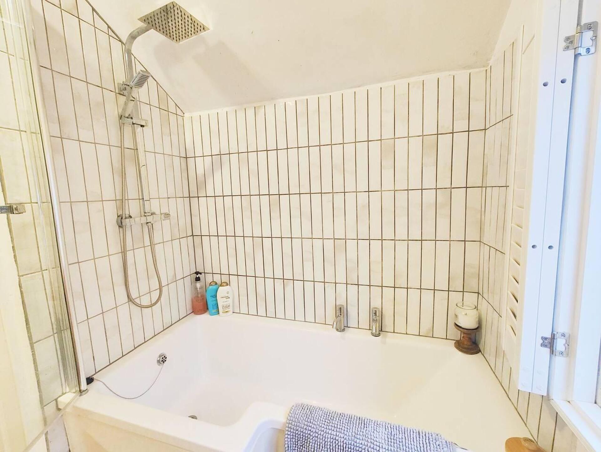A bathroom with a bathtub, a shower, and tiled walls.