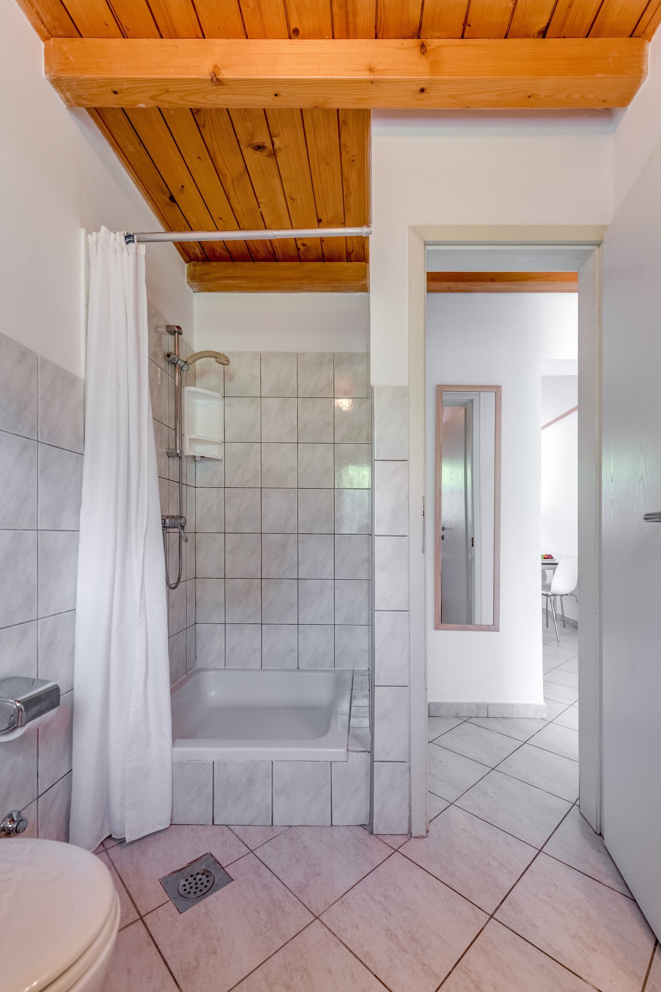 A modern bathroom with a shower, toilet, and bathtub.