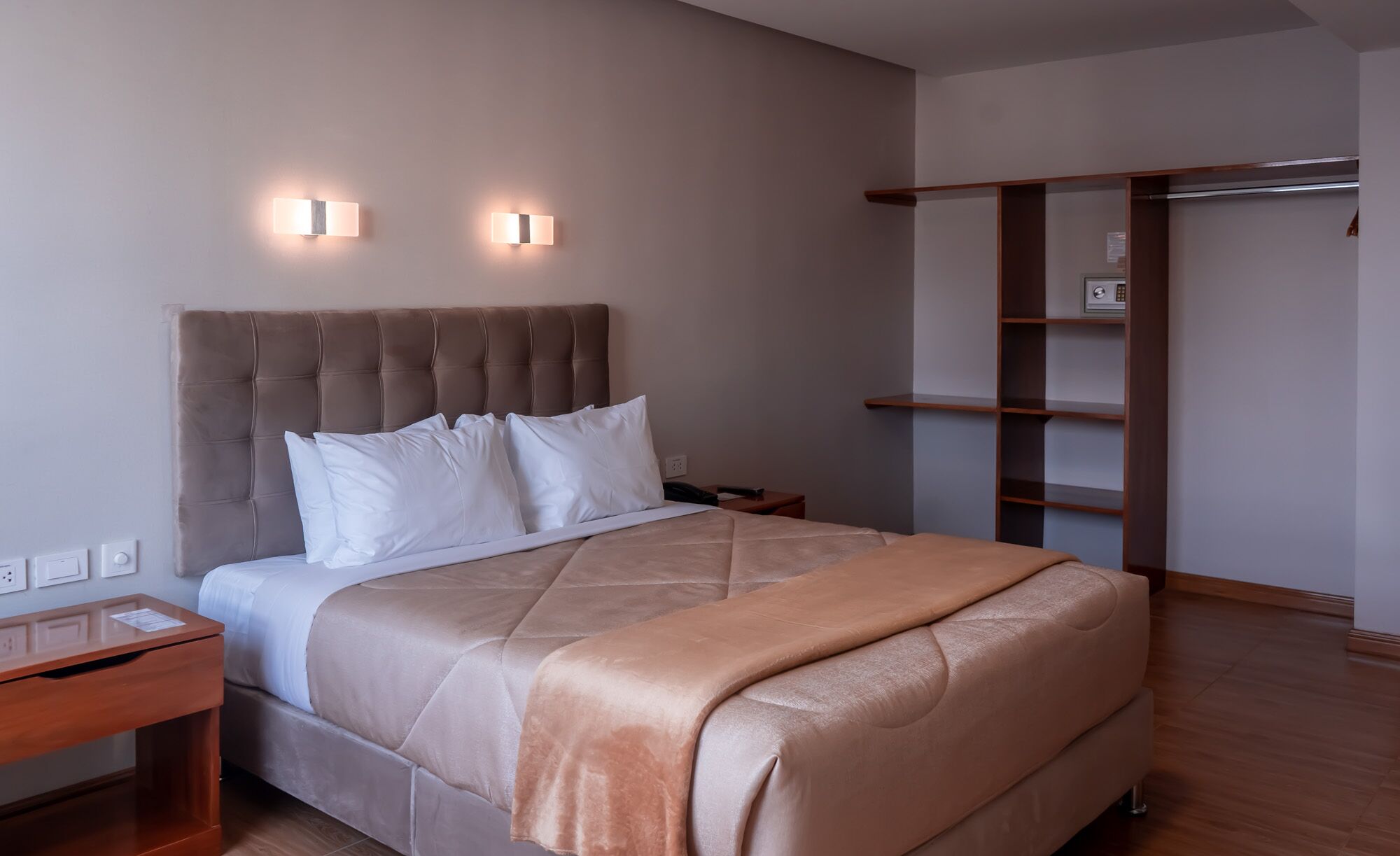 Une chambre à coucher bien rangée, avec un grand lit, des tables de chevet et une armoire.