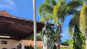 A statue of a mermaid with dolphins in a pool, surrounded by palm trees and a building with a tiled roof. - Free Beach&pool Access -vaes Luxury Escape (Discovery Bay)