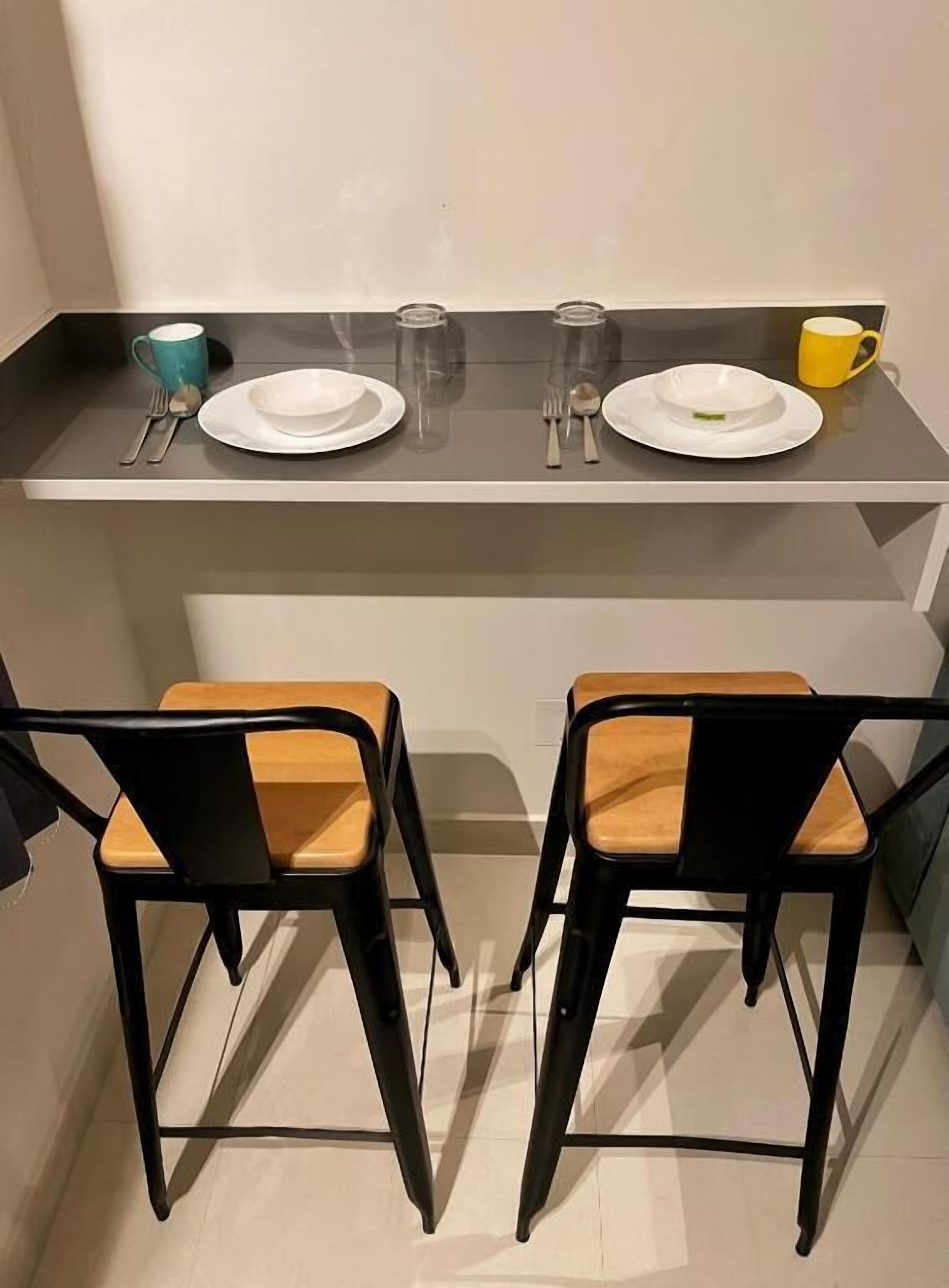 A small dining area with two chairs and a table set for two.