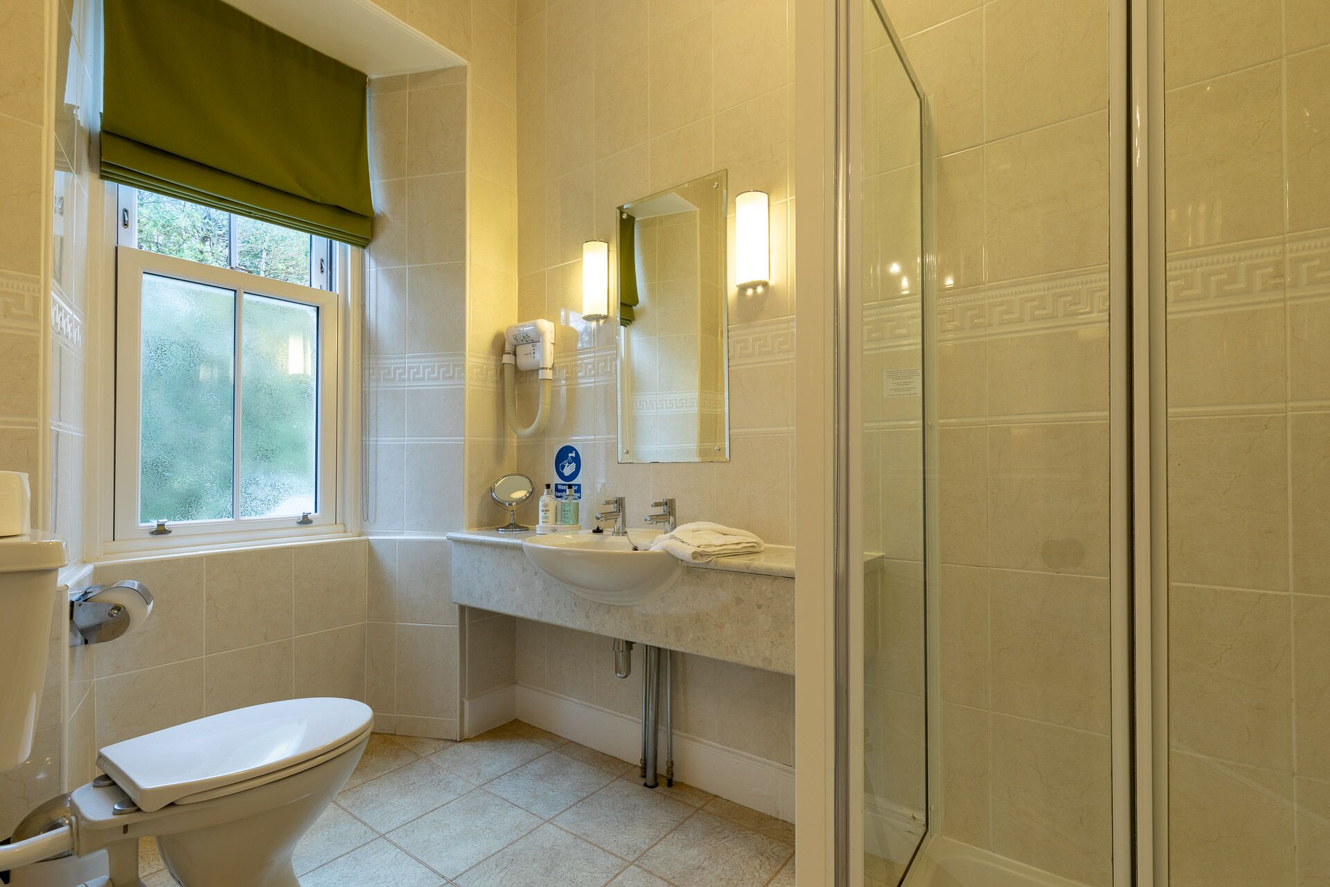 A bathroom with a toilet, sink, and shower.