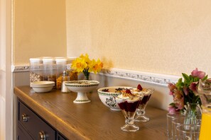 A kitchen counter with various items including a bowl, salt shaker, and flower arrangements. - Craigroyston House & Lodge (Pitlochry)