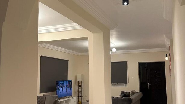 A spacious living area with a large TV, comfortable seating, and a modern design. - 3 Bed Apartment Sleeps 6 - Ensuites, Parking, Wifi (Freetown)