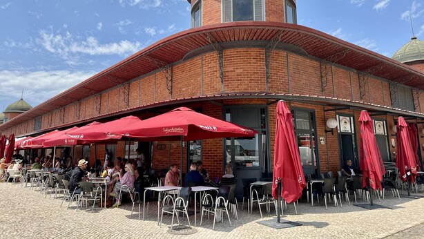 A brick building with a round tower and red umbrellas. - Casa Santiago & Mafalda Lux Home in Olhao, Algarve (Olhao)