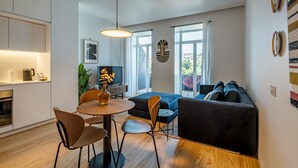 Een moderne woonruimte met een eethoek, een bank en een keuken.