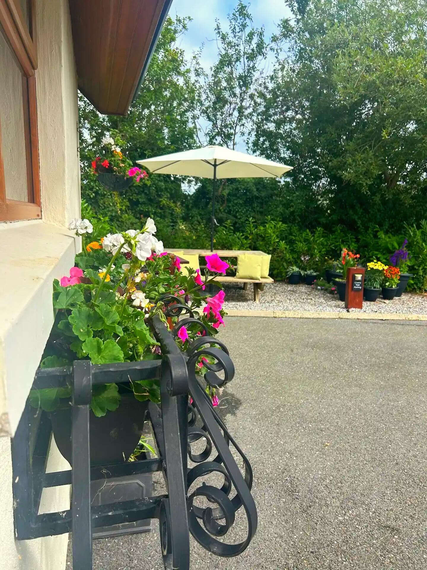 A garden area with a bench, a table, and a white umbrella.