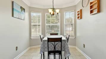 Un espace repas comprenant une table, des chaises et un lustre.