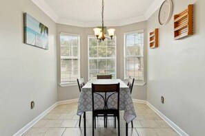 A dining area with a table, chairs, and a chandelier.
