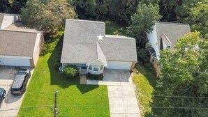 A residential area with houses, a driveway, and a lawn. - 3-bedroom home in the Mississippi Gulf Coast (Pass Christian)