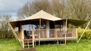 A wooden cabin with a balcony, surrounded by trees. - Rame- 2 Bedroom Safari Cabin Tent (Torpoint)