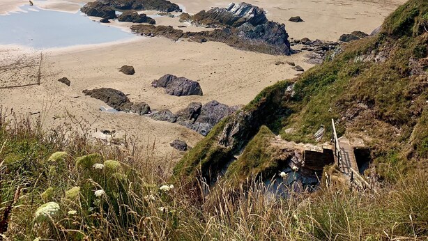 A coastal landscape with a sandy beach, rocky outcrops, and a clear view of the sea. - Rame- 2 Bedroom Safari Cabin Tent (Torpoint)