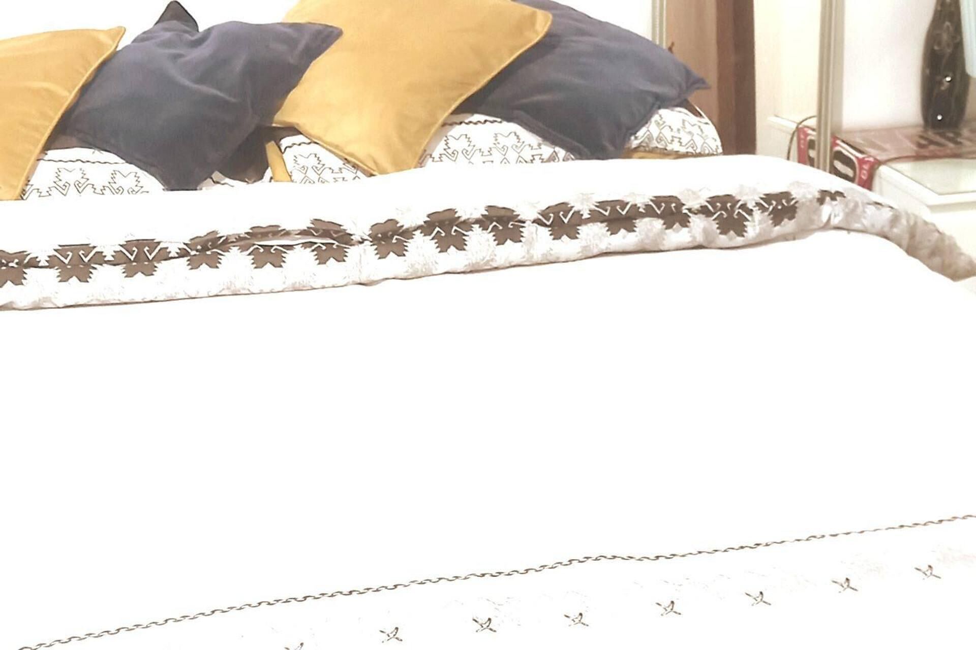 Un lit avec une couvre-lit à motifs et des oreillers.