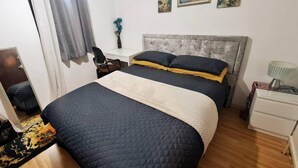 A bedroom with a bed, a desk, a chair, and a nightstand. - Lovely 2-bed Apartment in Battersea, London (London)