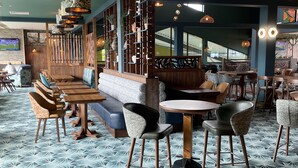 A restaurant interior with a herringbone patterned floor, wooden furniture, and a high ceiling with exposed beams. - Static Caravan - The Dizzard (Holsworthy)