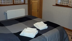 A room with a bed, a wooden wardrobe, and a radiator.