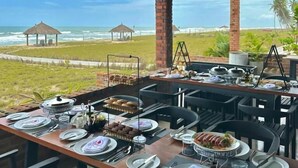 An outdoor dining area with a view of the beach and ocean. - Breezes  Beach Resort (Ekumfi Narkwa)