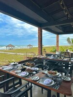 An outdoor dining area with a view of the beach and ocean.