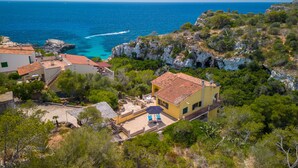 A coastal property with a patio area, a small pool, and a view of the sea.