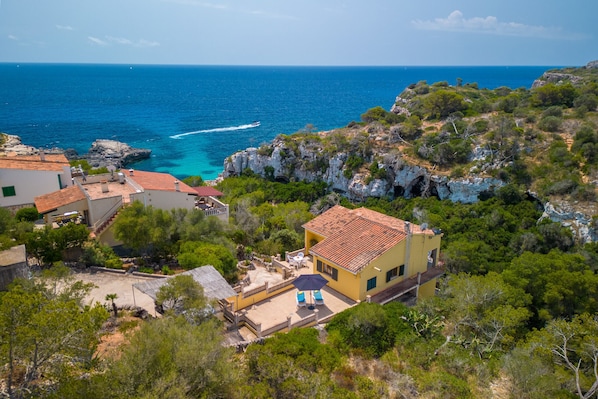 Une propriété située sur la côte, dotée d’un patio, d’une petite piscine et offrant une vue sur la mer.