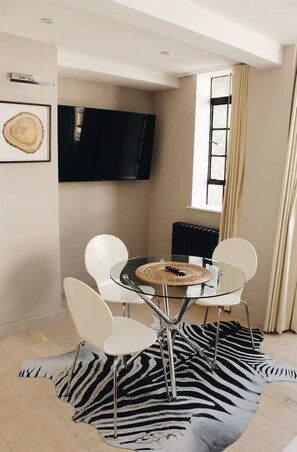Enjoy dining and entertainment in this cozy space with a round table, four chairs, and a flat-screen TV.