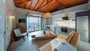 Eine moderne Küche mit Holzbalkendecke, einem Essbereich mit einer Bank und einem Sofa.