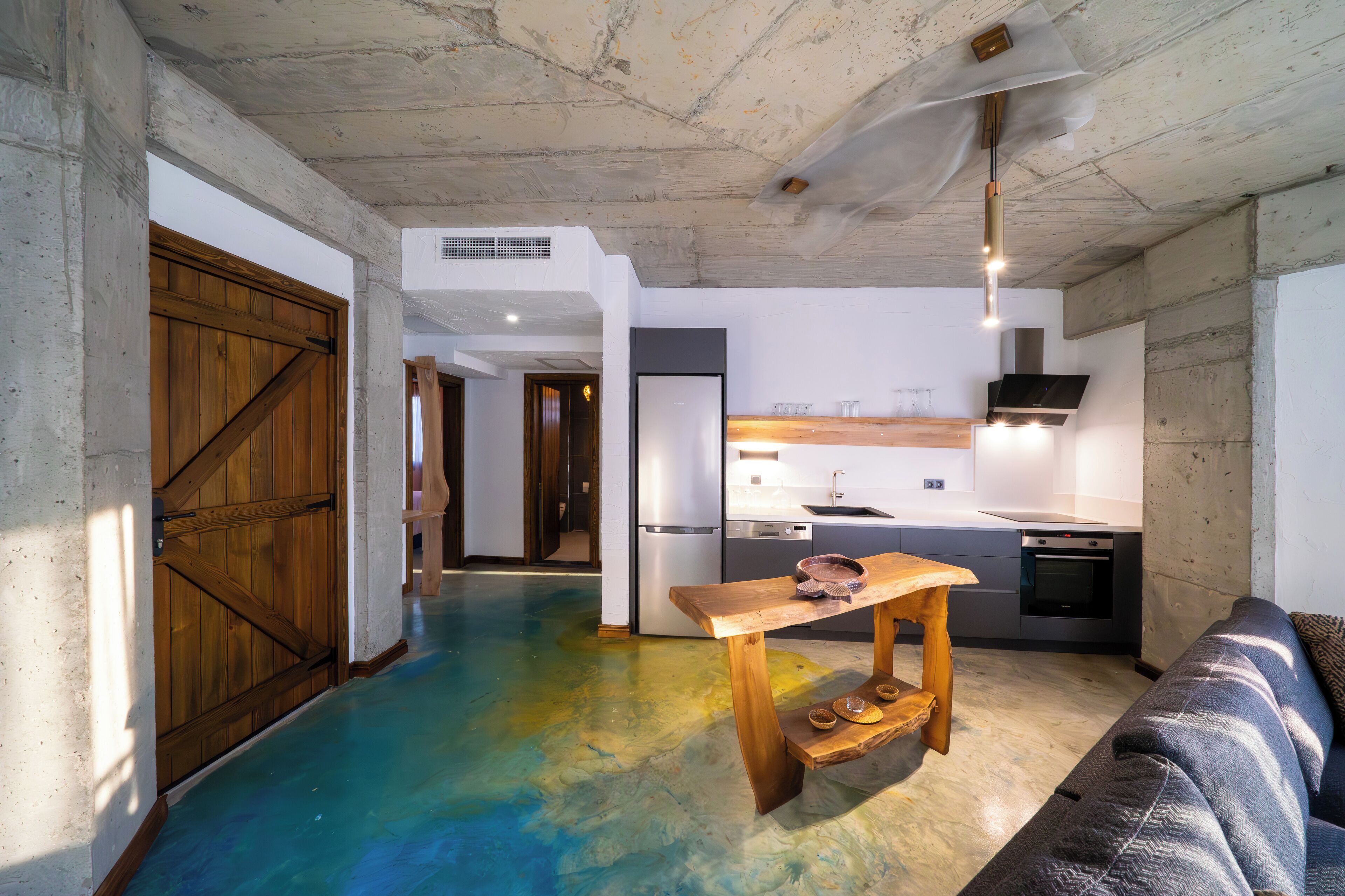 A modern kitchen with a wooden table and a built-in oven.