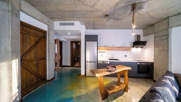 A modern kitchen with a wooden table and a built-in oven.