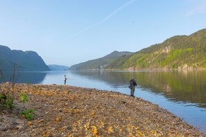 A rocky shoreline with a calm lake and hills in the background. - Sirdalsvatnet Hotel (Sirdal)