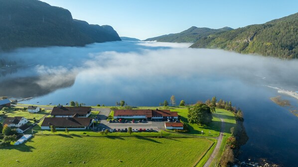 A lakeside property with a parking area, buildings, and a view of the lake and surrounding hills. - Sirdalsvatnet Hotel (Sirdal)