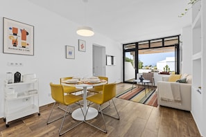 Un espace de vie moderne comprenant un coin repas, un canapé et une vue sur l’extérieur.