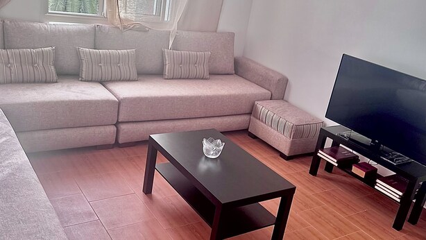 Een moderne woonkamer met een bank, een salontafel en een televisie.