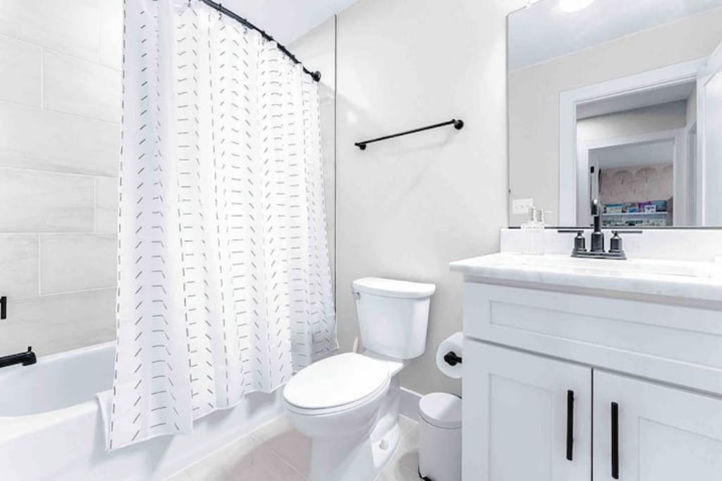 Ein Badezimmer mit Badewanne, Toilette und Waschtisch mit Schränken.