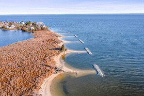 A coastal area with a sandy beach, a clear blue sea, and a small settlement with houses. - Waterfront, Dock+Kayak, Firepit, Game room, Potomac 2hrs to DC, Dogs+EV OK (Montross)