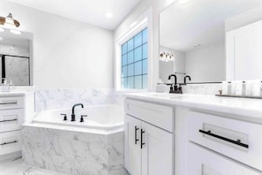 A modern bathroom with a white marble sink, a bathtub, and a large mirror. - Waterfront, Firepit, Kayak, Game room, Potomac 2hrs from DC, Dogs+EV OK (Montross)