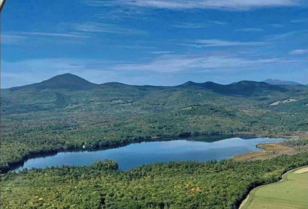 Un lac entouré de collines boisées.