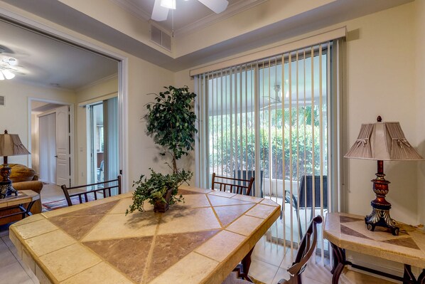 Enjoy meals in a cozy dining area with a large table, potted plant, and comfortable seating for two.