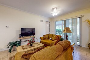 Relax in this stylish living room with a large flat-screen TV, comfortable sofa, and a coffee table.