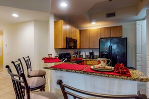 Enjoy cooking and dining in this well-equipped kitchen with a central island, microwave, coffee maker, and refrigerator.