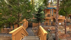 A wooden staircase leading to a building with balconies, surrounded by trees and rocks. - Alpine Alcove Near Kings Beach - Private Sleeping Nook - Pet Friendly (Tahoe Vista)