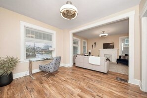 Relax in a comfortable living area with a sofa, armchair, and fireplace, offering a view of the outdoors.