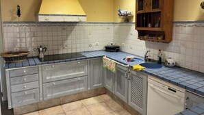 A kitchen with a tiled backsplash, a sink, a stove, and cabinets.