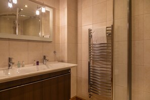A modern bathroom with a large mirror, a sink, and a towel rack. - Vantage Point, Hillfield Village (Dartmouth)