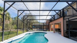 A swimming pool with a glass enclosure, surrounded by a patio area with outdoor furniture. - Beautiful 5Bd Single Family w Game Room 106 Lake Wilson Preserve (Davenport)
