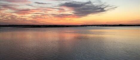 A calm body of water reflecting the sky during sunset.