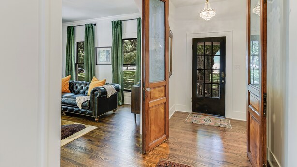 A spacious room with a large bed, a wooden door, and a chandelier. - The Ella Norah. A Luxury Retreat. Pool and Spa. Steps to Main Street.  (Smithville)