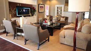 A living room with a television, two sofas, a coffee table, and a lamp.