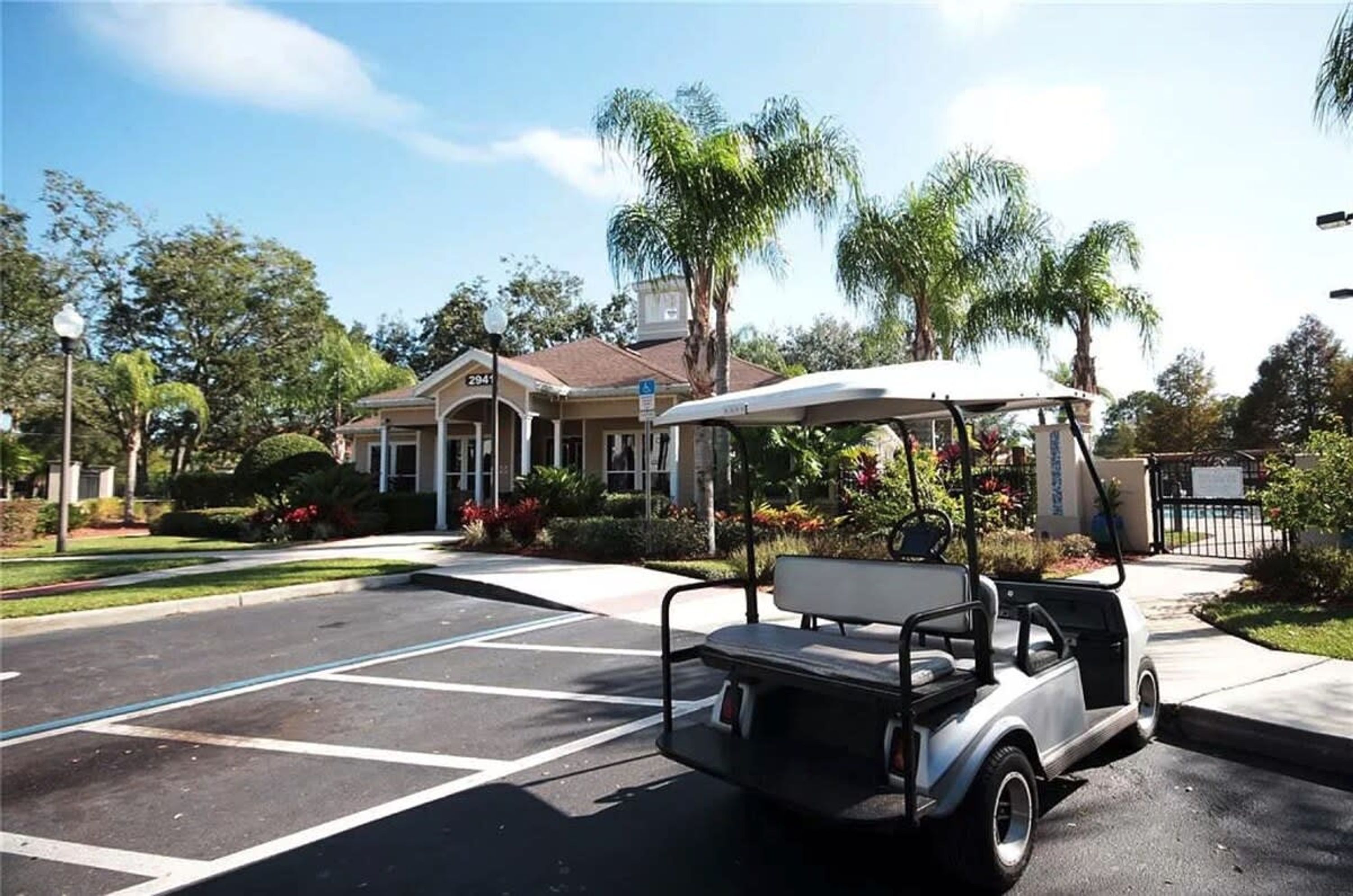 A golf cart parked in a parking lot with a building in the background.