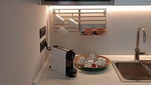Une cuisine moderne équipée d’un four encastré, d’une machine à café et d’un évier.
