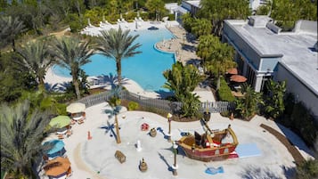 Ein Luftbild eines Resorts mit großem Pool, Palmen und Liegestühlen.